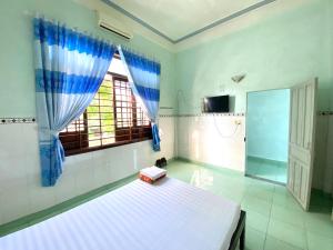 a bedroom with a bed and a window at Quốc Khánh Guest House in Thôn Lại Thê