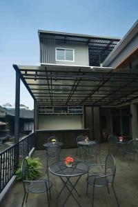 a patio with tables and chairs on a balcony at Inn Stations Hostel in Bangkok