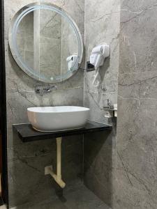 a bathroom with a sink and a mirror at Hotel Ace Inn in Dr. Babasaheb Ambedkar International