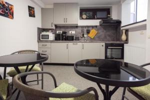 a kitchen with a table and two chairs and a table at ARINI WHITE HOUSE in Sibiu