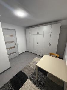 an empty room with a table and white cabinets at Apartament in Chişinău