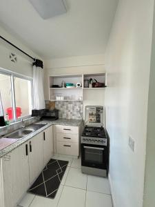 a small kitchen with a stove and a sink at BMW Buxton point Apartment in Mombasa