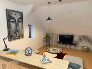 a living room with a table with a picture of a face on the wall at Ferienwohnung Ankerplatz in Rankwitz