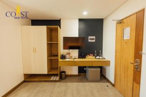 a room with a desk with a computer and a door at Coast Wise Hotel Dumaguete in Dumaguete