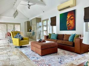 a living room with a couch and a chair at Baan Tai Tara 4, Private Pool Villa by Ban Tai Beach in Ban Tai
