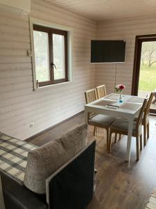 a dining room with a table and chairs and a television at Aru talu külalistemaja in Iilaste