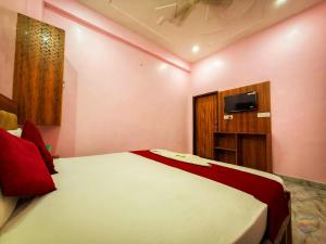a bedroom with a bed and a tv on the wall at Hotel Vrinda mohan kunj Near Prem Mandir in Vrindāvan