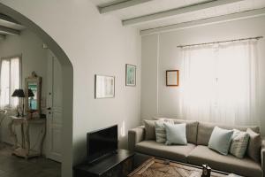 a living room with a couch and a tv at Dinora Stone Villa, Pool & Sea Views in Tinos in Agios Ioannis