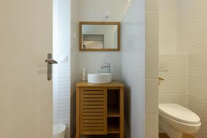 a bathroom with a sink and a toilet and a mirror at Hôtel Le Square in Saint-Pierre-dʼOléron