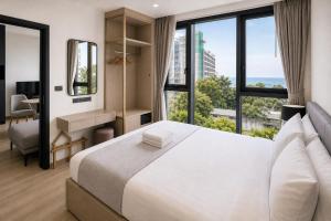 a bedroom with a large bed with a large window at The Edge central pattaya in Pattaya +87 photos