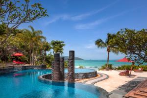 a pool at a resort with the ocean in the background at Anantara Maia Seychelles Villas in Mahe