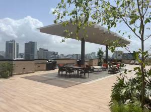 a patio with tables and chairs and a large umbrella at Torre meridt in Santo Domingo