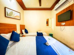 a hotel room with two beds and a flat screen tv at Hotel Vrinda mohan kunj Near Prem Mandir in Vrindāvan