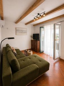 a large green couch in a living room at Apartments Casa al Vento in Donja Klada