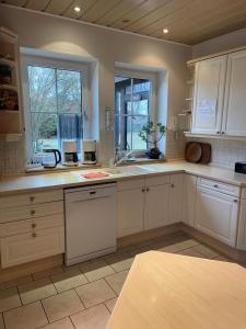 a large kitchen with white cabinets and a window at Gästehaus Wedework in Wedemark