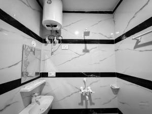 a black and white bathroom with a sink and a mirror at Hotel Vrinda mohan kunj Near Prem Mandir in Vrindāvan