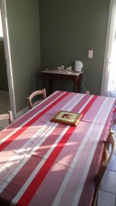 una cama con una manta a rayas encima en Chambres d'Hôtes Les Maïsses en Mison