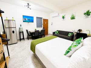 a bedroom with a large bed and a dining room at Cabo Downtown Studios in Cabo San Lucas
