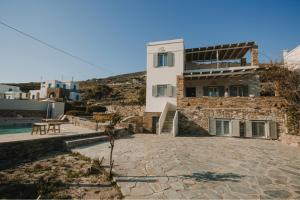a villa with a swimming pool and a house at Dinora Stone Villa, Pool & Sea Views in Tinos in Agios Ioannis