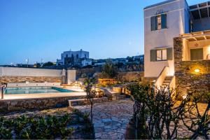 a villa with a swimming pool in front of a building at Dinora Stone Villa, Pool & Sea Views in Tinos in Agios Ioannis