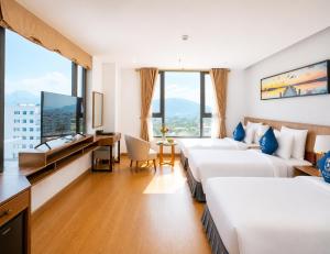 a hotel room with three beds and a flat screen tv at Sea Soul Hotel in Nha Trang +149 photos