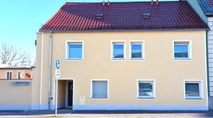 ein großes gelbes Haus mit rotem Dach in der Unterkunft minimalissimo in Großenhain