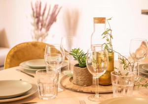 a table with glasses and plates and a bottle of wine at L'escale - proche Homme de Fer in Strasbourg