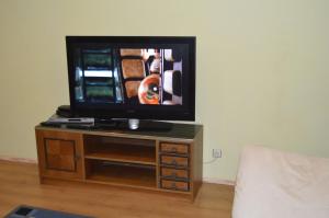 a flat screen tv sitting on top of a wooden table at Uus 13b, Beautiful 3-bedroom Apartment - 3 big beds in Tartu