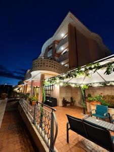 a balcony of a building at night with benches at Hotel Valle Rossa in San Giovanni Rotondo