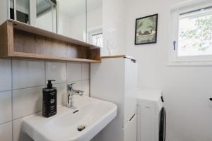 a white bathroom with a sink and a window at Danube Rooms Abteistrasse - Self Checkin - kostenlos Parken direkt an der Unterkunft - Ideal für Geschäftsreisende und Städtetrips in Passau