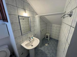 a small bathroom with a sink and a mirror at Christina's Apartments in Vathi