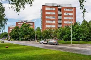 two cars parked on a street in front of a building at Aava's apt. FREE Parking in Pori
