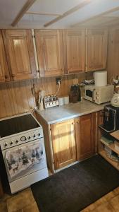a kitchen with wooden cabinets and a white stove top oven at Chata Bambi, Tatranská Štrba pri zubačke in Štrba