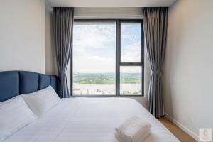 a bedroom with a bed with a large window at Lumière Royal Sky Residence in Ho Chi Minh City