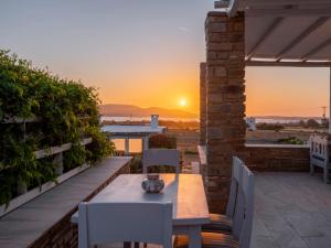 a patio with a table and chairs and the sunset at Angel Serenity Villa in Kampos Paros