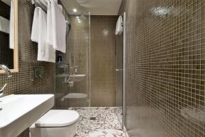 a bathroom with a shower and a toilet and a sink at Mimi's Hotel Soho in London +37 photos