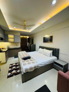 a bedroom with a large bed and a kitchen at Candlewick Homestays in Jaipur +2 photos