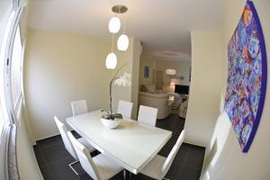 a dining room with a white table and white chairs at Apartment Zubčić in Zadar