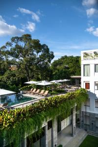 a building with a pool and chairs and umbrellas at Treeline Urban Resort in Siem Reap