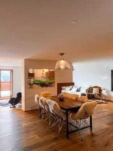 a living room with a dining room table and a couch at Evasion Alpine in Crans-Montana
