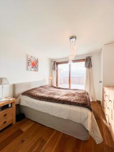 a bedroom with a large bed and a window at Evasion Alpine in Crans-Montana