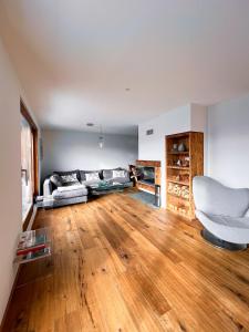 a living room with a couch and a wooden floor at Evasion Alpine in Crans-Montana +2 photos