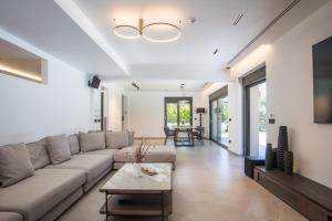 a living room with a couch and a table at Casadi Luxury Villa in Ialysos