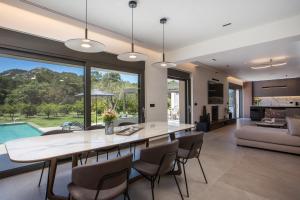 a dining room and living room with a table and chairs at Casadi Luxury Villa in Ialysos
