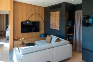 a living room with a white couch and a tv at The Valley Resort in Vama Buzăului