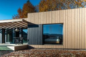 a house with glass doors and a bed in it at The Valley Resort in Vama Buzăului
