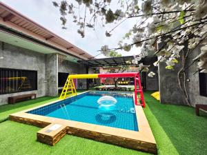 a backyard with a pool and a playground at Tiki Pool Pattaya in Ban Nong Pla Lai