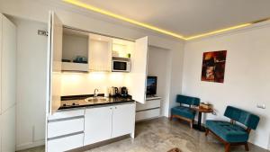 a kitchen with white cabinets and a sink in a room at White Tower Mamaia Beach 505 in Mamaia