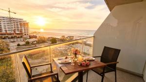 a table on a balcony with a view of the beach at White Tower Mamaia Beach 505 in Mamaia