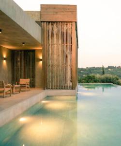 a house with a swimming pool with a table at Olea All Suite Hotel, a Member of Design Hotels in Tsilivi